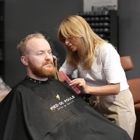 жінка стриже чоловіку бороду